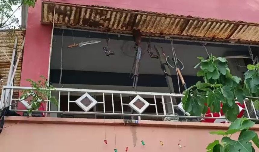 Balkonunda silah, balta ve kılıç sergiliyor